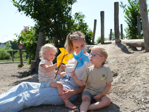 kind blaast tegen papieren windmolen