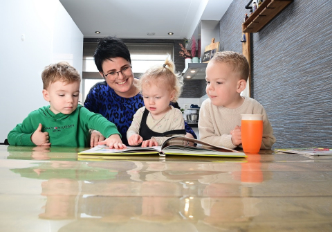 Kinderen lezen samen een boekje met de gastouder
