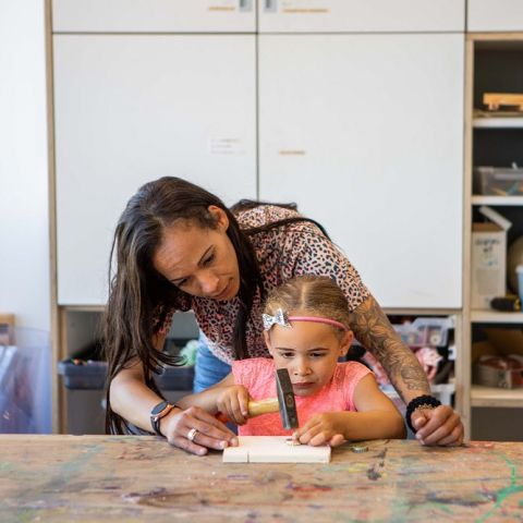 Pedagogisch medewerker en meisje timmeren