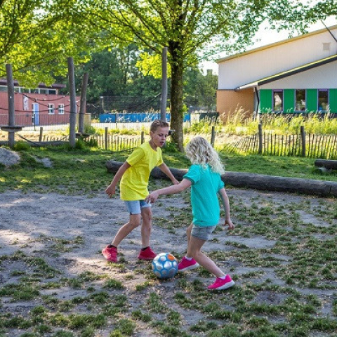 Jongen en meisje voetballen