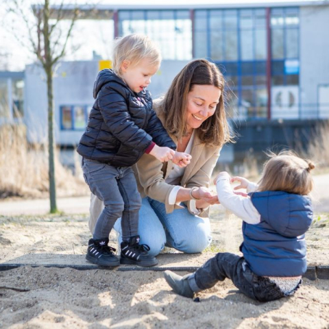 Gastouder is buiten met twee kinderen aan het spelen